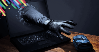 a pair of black gloves sitting on top of a laptop computer