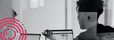 a person sitting at a desk with a laptop and a phone