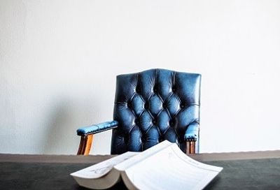 a blue chair sitting on top of a table next to a book