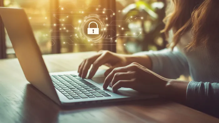 a woman typing on a laptop with a padlock on the screen