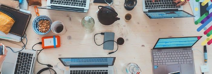 a group of laptops sitting on top of a wooden table