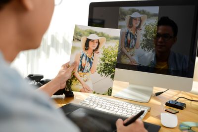 a man sitting in front of a computer with a picture of a woman on it