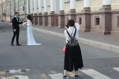 A photographer taking a photo of a bride and groom.