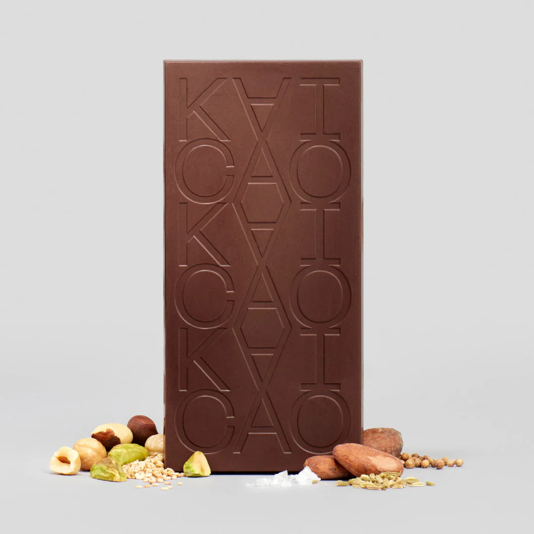 A bar of Kaicao 75% Dark Chocolate with Dukkah, Kokoa Kamili, Tanzania, with nuts and cacao nibs alongside