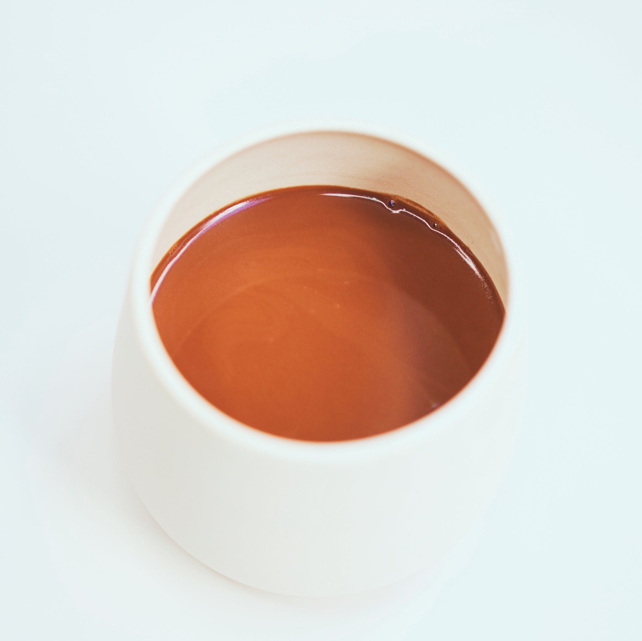 a white cup filled with Focus Ceremonial Cacao by Kaicao on top of a white table