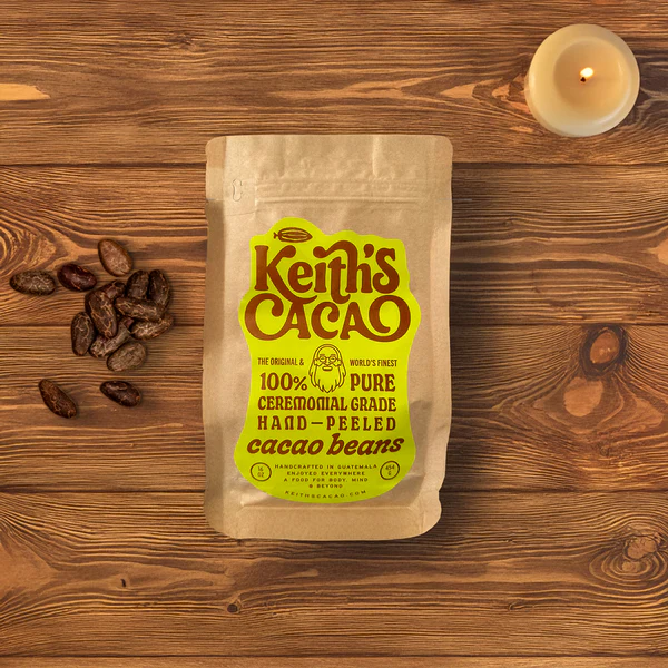 A bag of Keith's Cacao Ceremonial Cacao beans sitting on top of a wooden table.