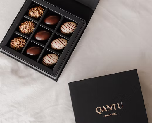 A box of gourmet easter chocolates sitting on top of a table.