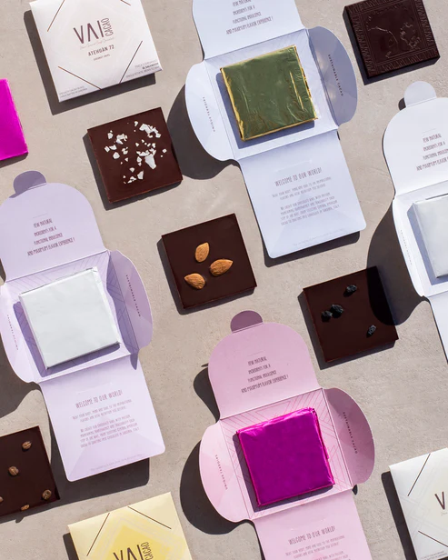 A variety of Vai Cacao Chocolate bars laid out on a table.