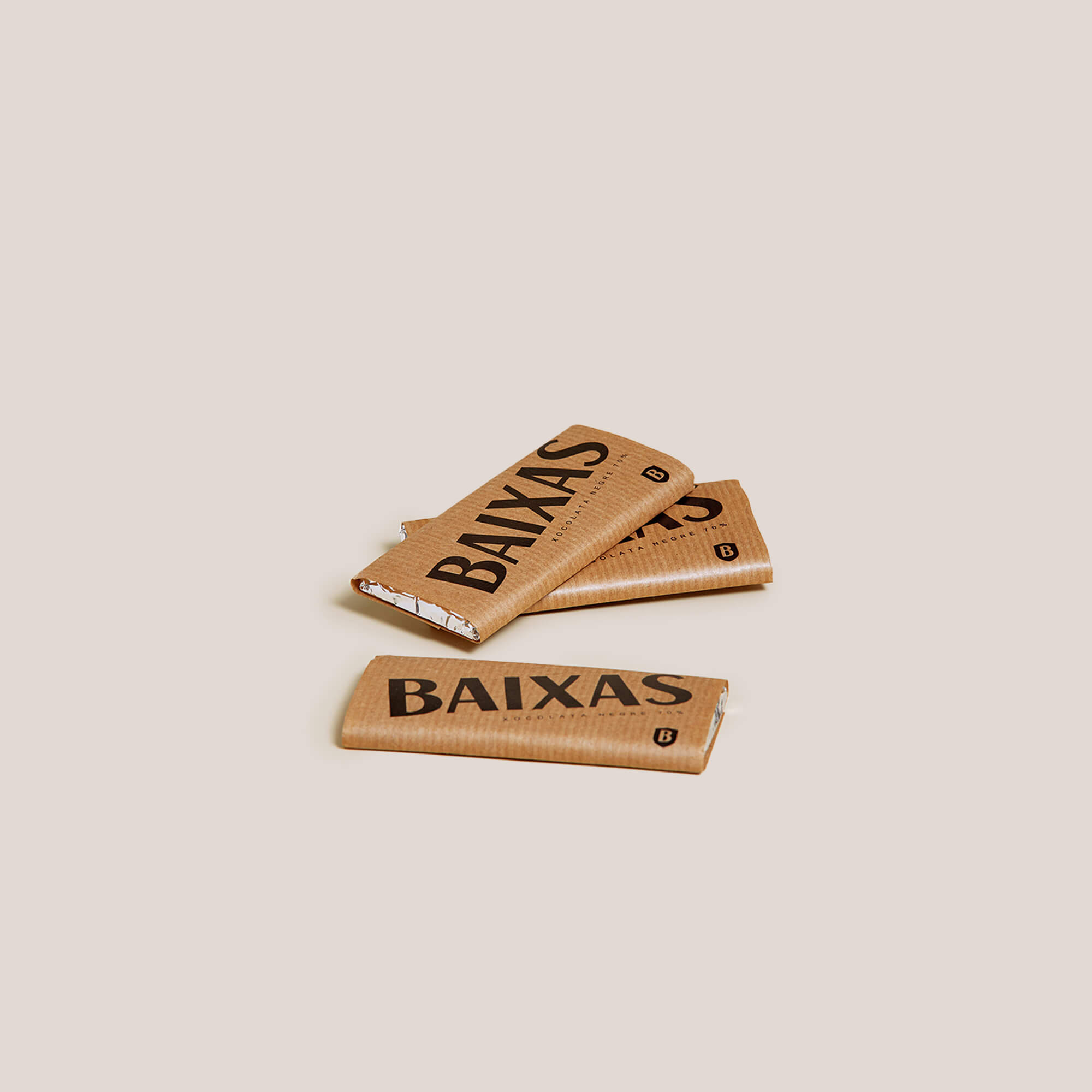 Three slabs of BAIXAS Breakfast Chocolate, wrapped in brown paper.