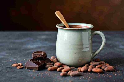 A cup of hot chocolate with a spoon in it.