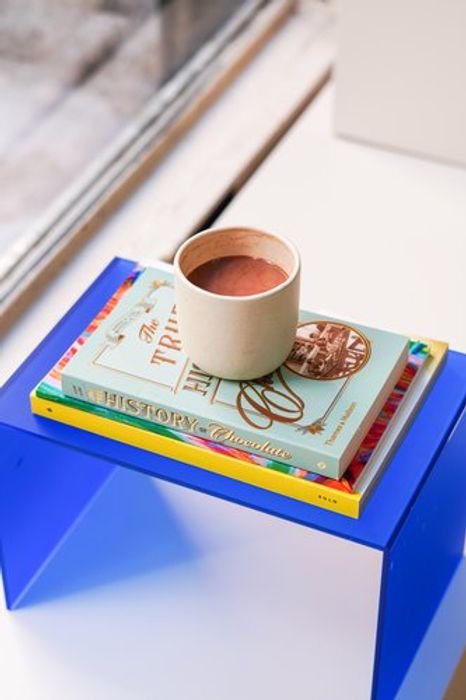 a cup of coffee on a stack of books