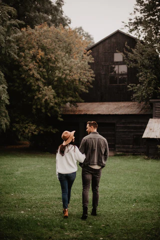 a man and a woman walking through a field