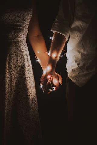a couple holding hands with sparklers in their hands