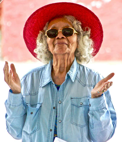 an older woman wearing a red hat and sunglasses
