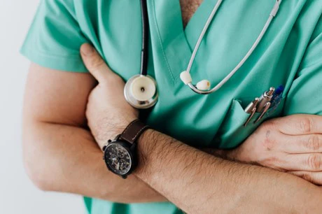 a man in a green shirt with a stethoscope on his arm