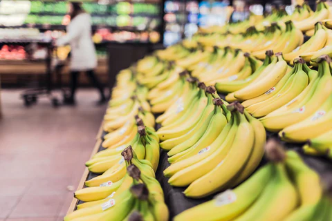 bunches of bananas are lined up in a grocery store