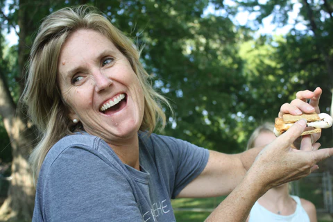 a woman is holding a sandwich in her hand