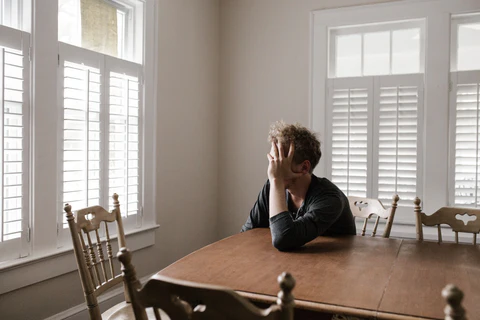 a man sitting at a table in front of a window