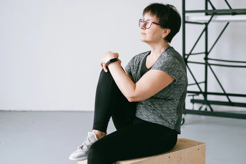 a woman sitting on top of a wooden box