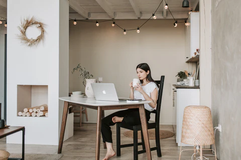 a woman sitting at a table with a laptop