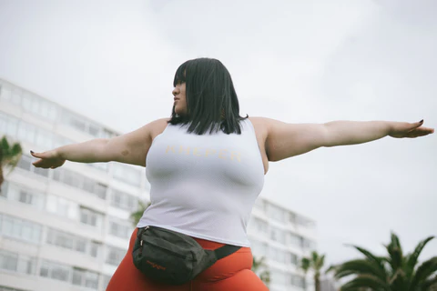 a woman in a white tank top and red leggings