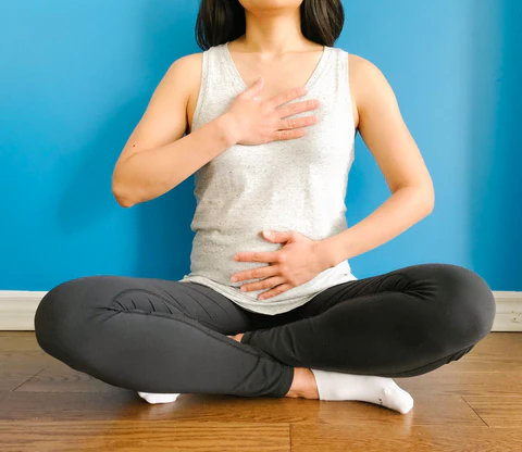a woman sitting on the floor in a yoga pose