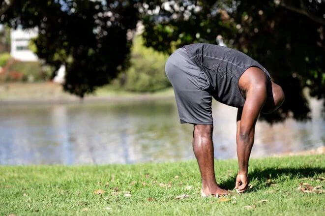 a man doing a yoga pose in a park