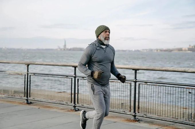 a man running on a sidewalk near the water