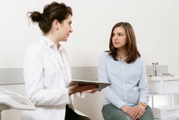 a woman talking to another woman in a room