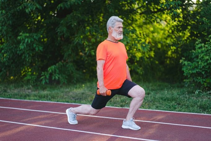 an older man is running on a track