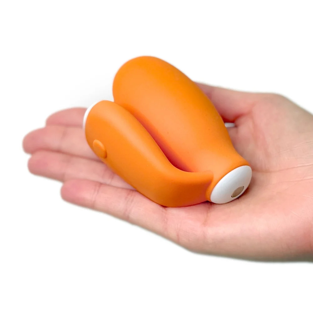 a hand holding a small orange object in it's palm