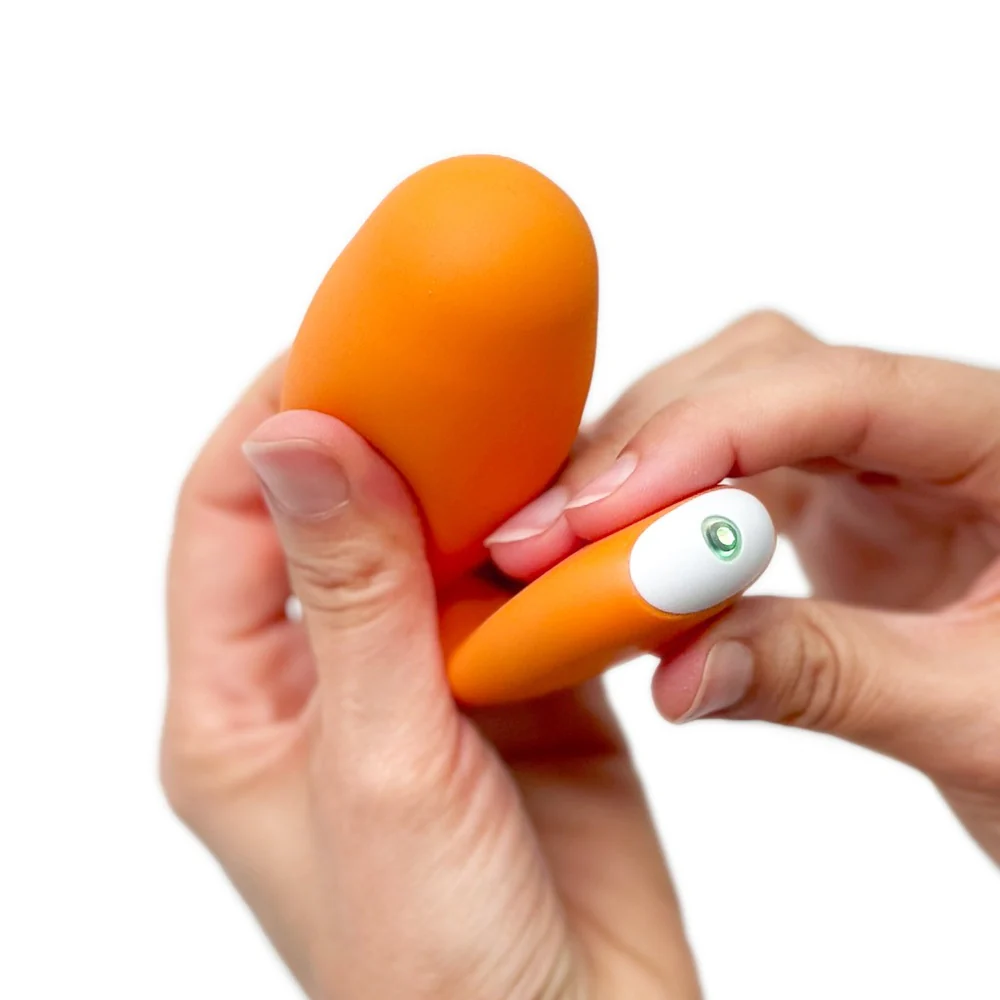 a woman holding an orange toy in her hands