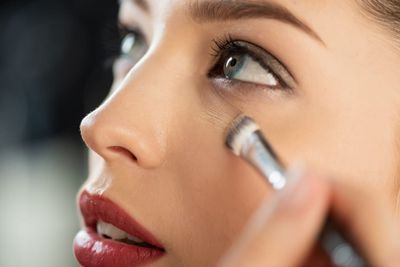 What makeup brush to use for concealer: a woman doing her makeup.