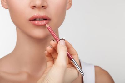 Can lip liner be used as eyeliner: a woman using lip liner.