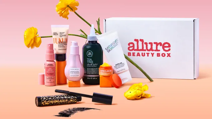 A box of Allure beauty products and a flower.