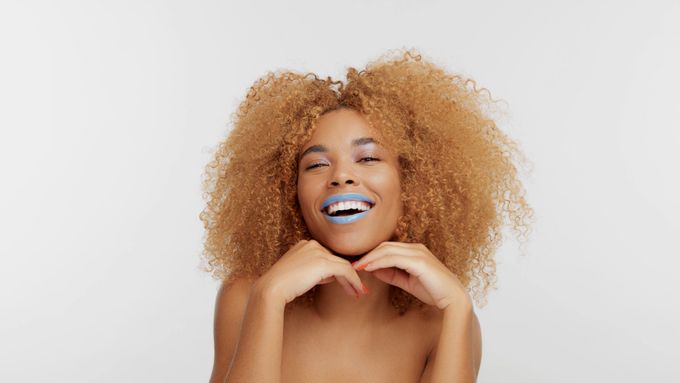 a woman smiling and waring a trending blue bold lipstick 