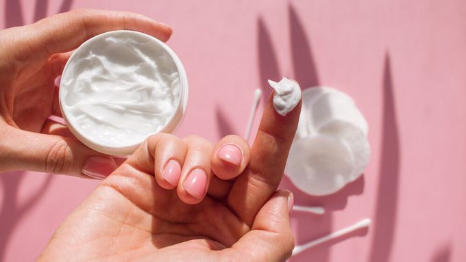 A person holding a moisturizer.