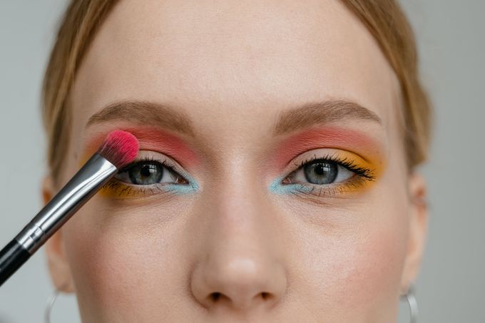 a woman with a brush on her eye