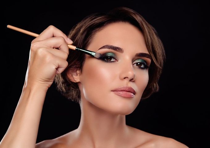 A woman with makeup brushes in her hair.