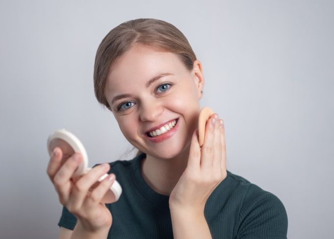 A woman is holding a brush and smiling