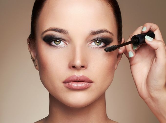 A woman is putting on makeup with a brush.