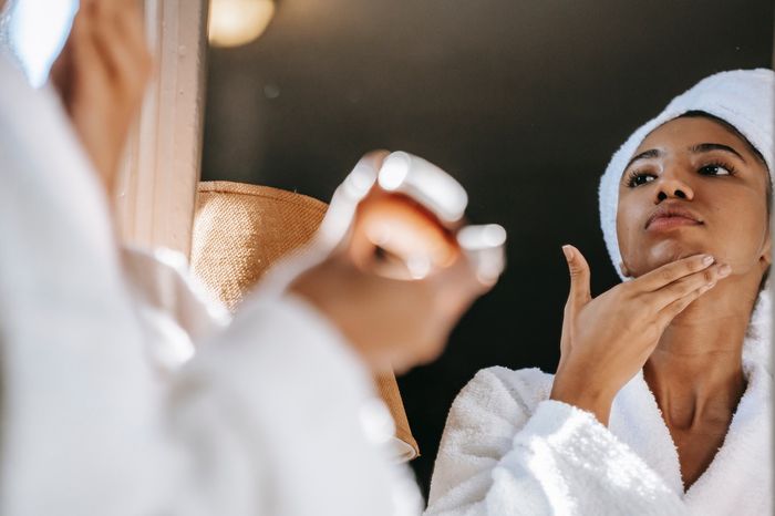 a woman in a towel is looking at her reflection in a mirror