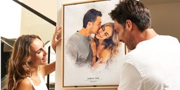 a man and a woman looking at a watercolor canvas