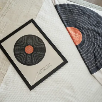 a record sitting on top of a bed next to a pillow