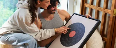 a man and woman sitting on a couch looking at a picture