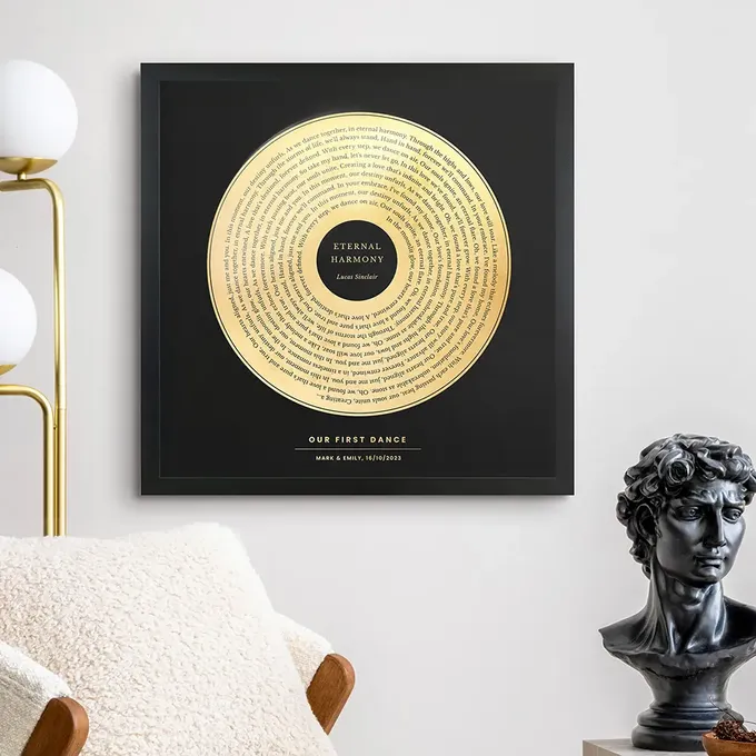 a black and gold wall hanging above a white chair
