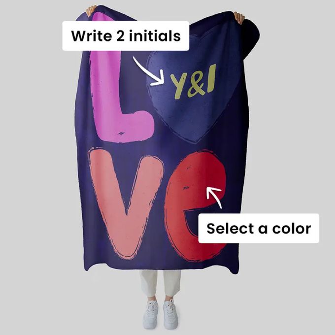 a woman is holding up a blanket with the words love written on it