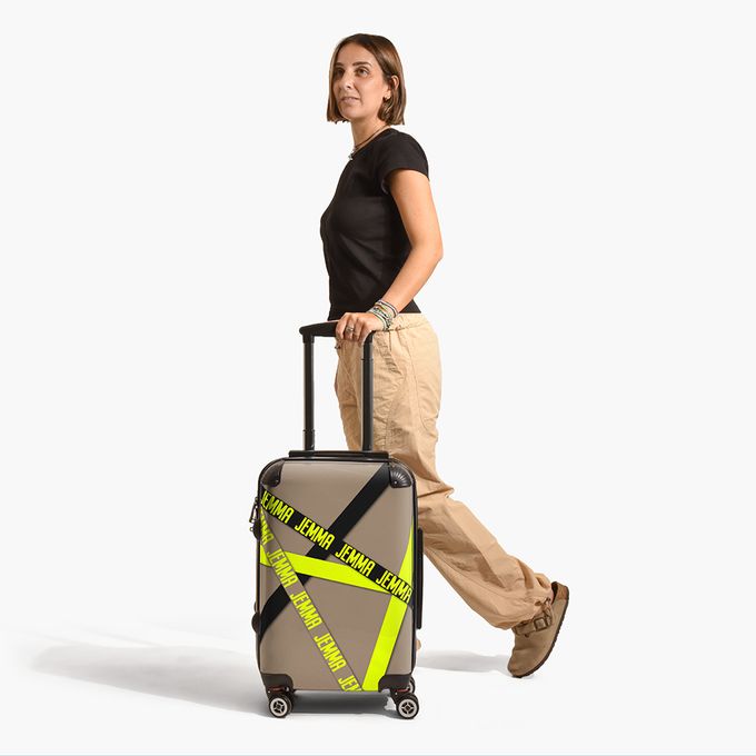 a woman walking with a suitcase with a yellow tape on it