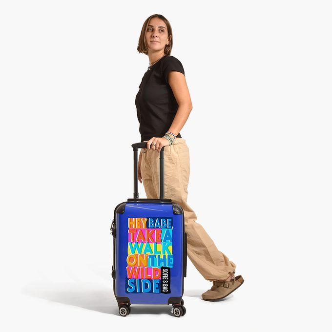 a woman is standing with a rolling suitcase