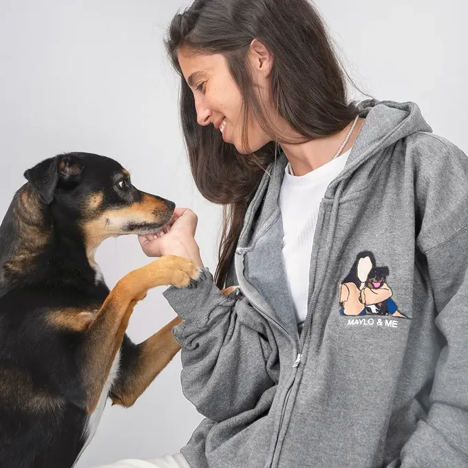 a woman petting a dog with a smile on her face